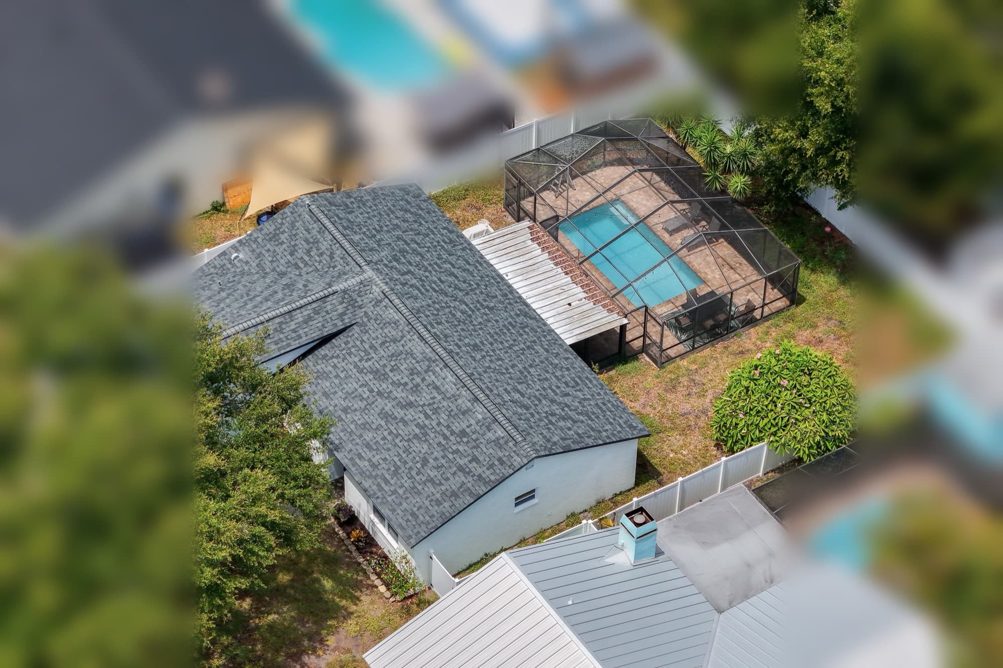 Aerial view of the home, screened pool, and fenced backyard