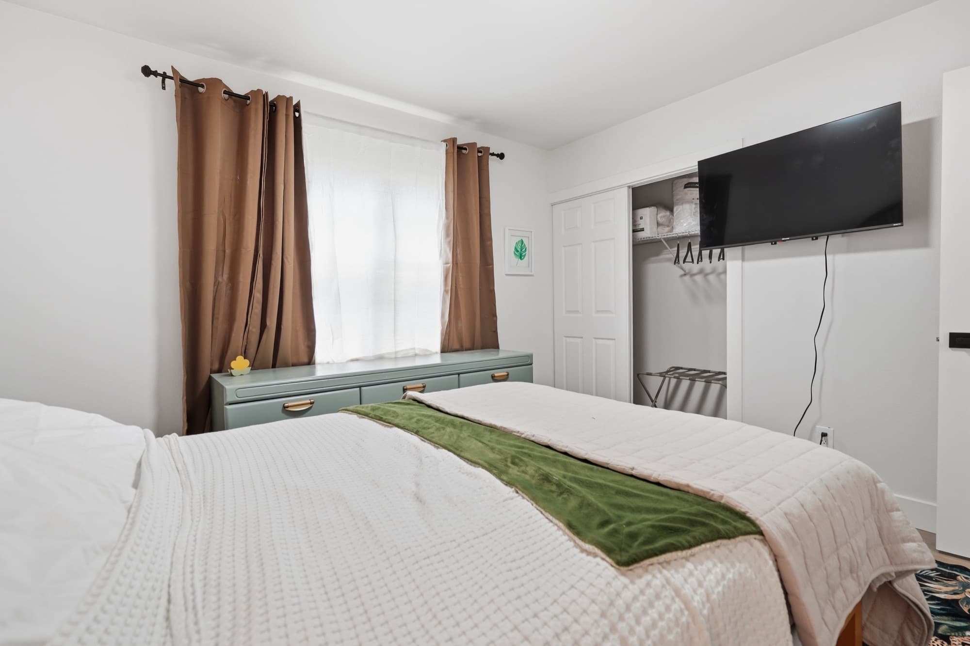 Bedroom 2 with wall-mounted smart TV and closet